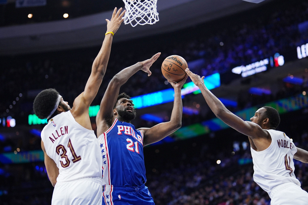 Philadelphia 76ers' Joel Embiid, center, goes up for a shot between Cleveland Cavaliers' Jarrett Allen, left, and Evan Mobley during the first half of an NBA basketball game Wednesday, Jan. 14, 2026, in Philadelphia. 