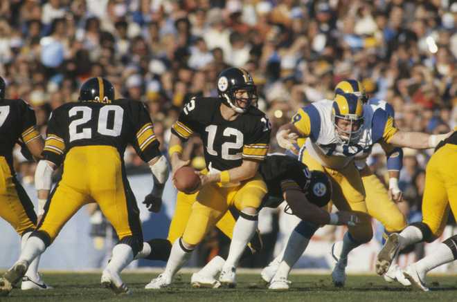 PASADENA, CA - JANUARY 20: Quarterback Terry Bradshaw #12 of the Pittsburgh Steelers looks to hand off the ball during Super Bowl XIV against the Los Angeles Rams at the Rose Bowl on January 20, 1980 in Pasadena, California. The Steelers defeated the Rams 31-19. (Photo by Focus On Sport/Getty Images)