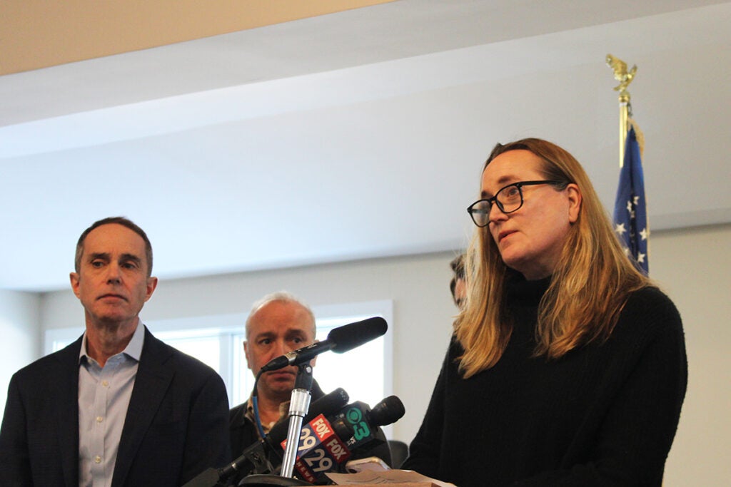 Kristine Wojnovich speaks into a microphone at a podium