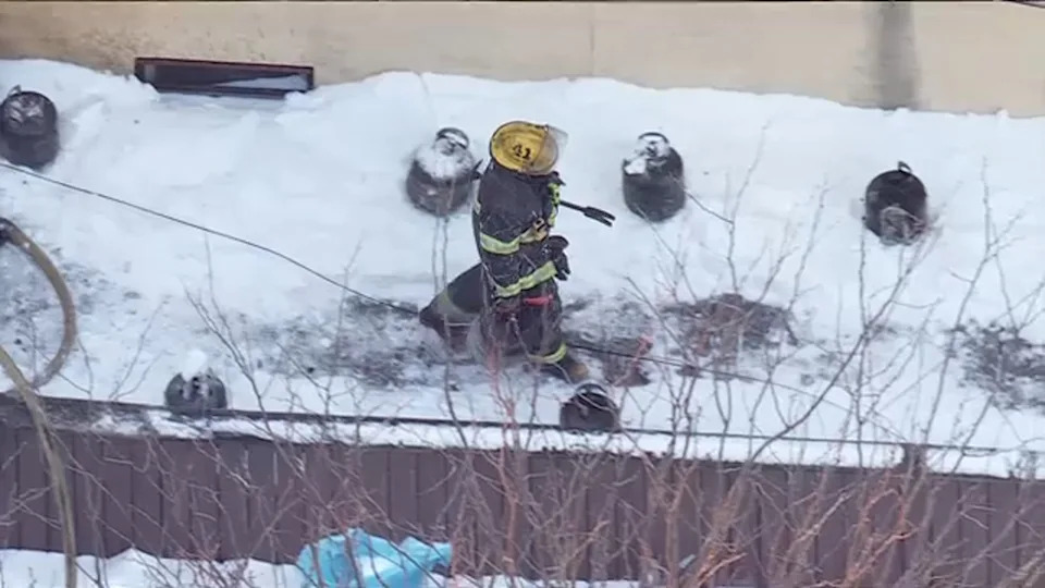 Firefighters remove several propane tanks that caught on fire outside of a business in Philadelphia's Roxborough neighborhood.