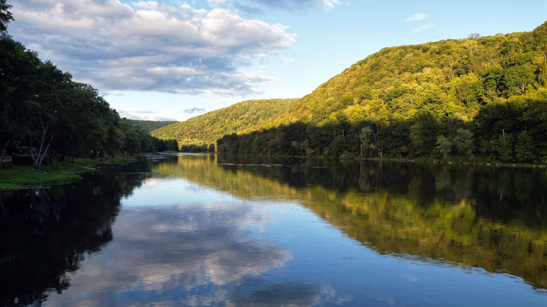 The Allegheny River flows between wooded hills
