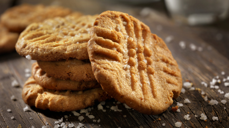 Peanut butter cookies are stacked on a table