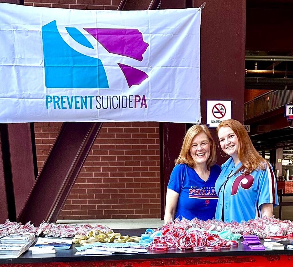 Amanda Blue (left) and Hannah Metzger are seen under a banner that says ''Prevent Suicide PA''