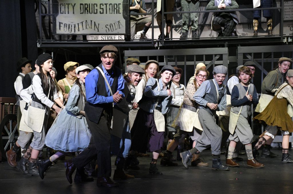 students performing in costume on stage