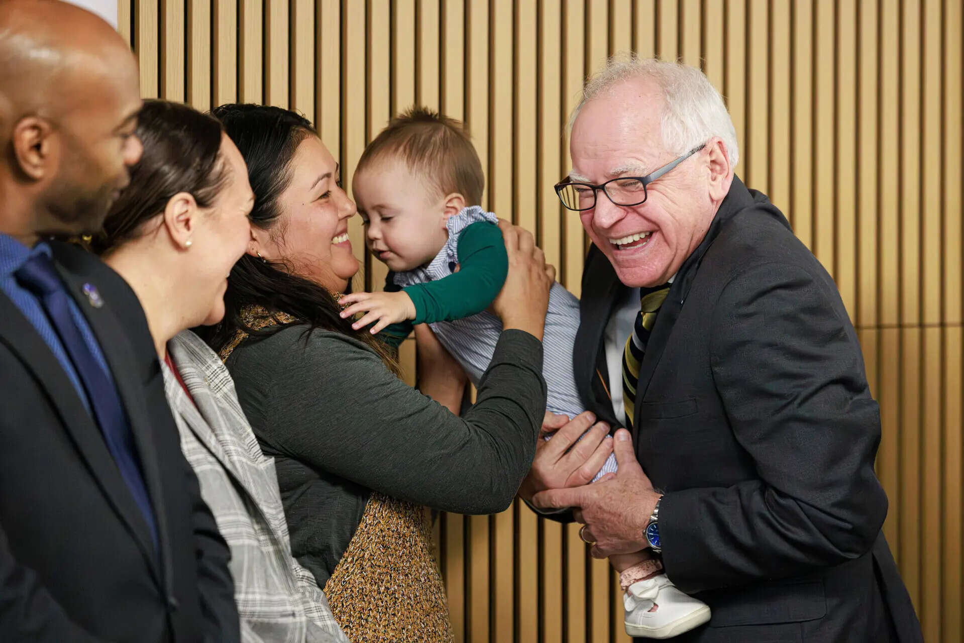 Gov. Tim Walz smiles at a child before speaking during a press conference on Tuesday, Jan. 6, 2026 at the Coliseum Building in Minneapolis. (Kerem Yücel/Minnesota Public Radio via AP) Tim Walz