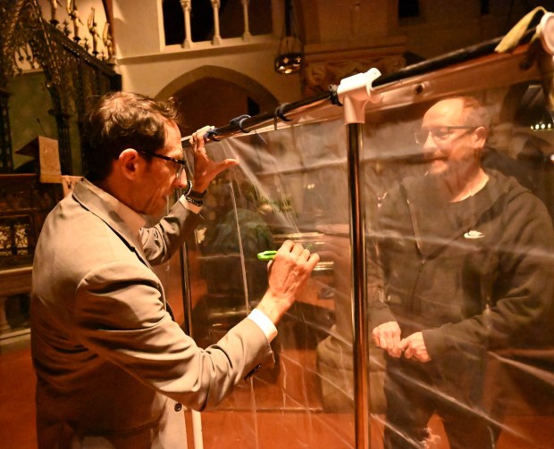 Allentown Mayor Matt Tuerk participates in a pain into power activity after a vigil for Renee Nicole Good, the woman shot and killed by a federal immigration agent in Minneapolis, on Friday, Jan. 9, 2026, at the Cathedral Church of the Nativity in Bethlehem. For the activity people were asked to look into a shower curtain and write what they saw on the other side. (Amy Shortell/The Morning Call)