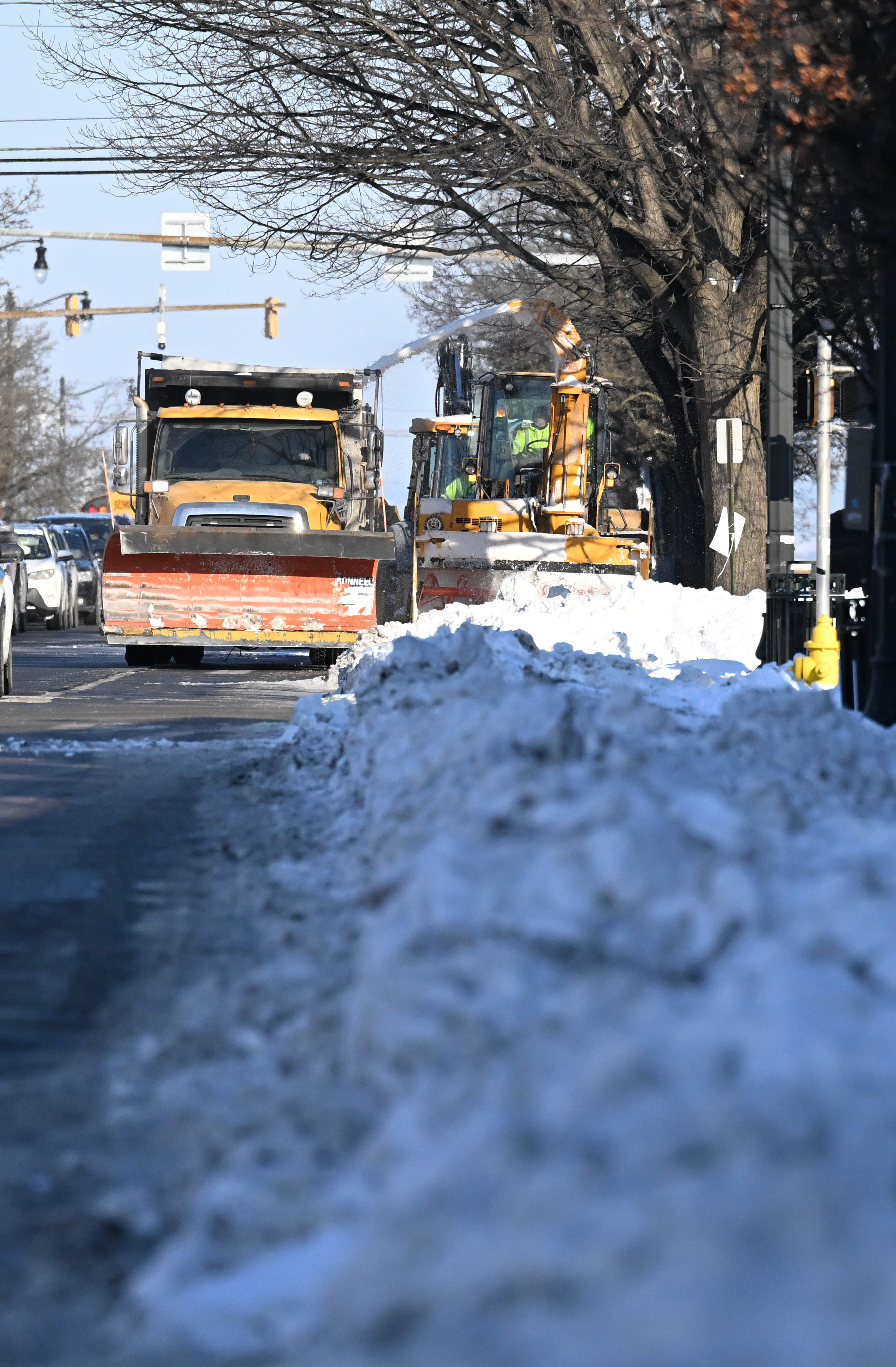 Workers from the Allentown Public Works Department clear snow from...