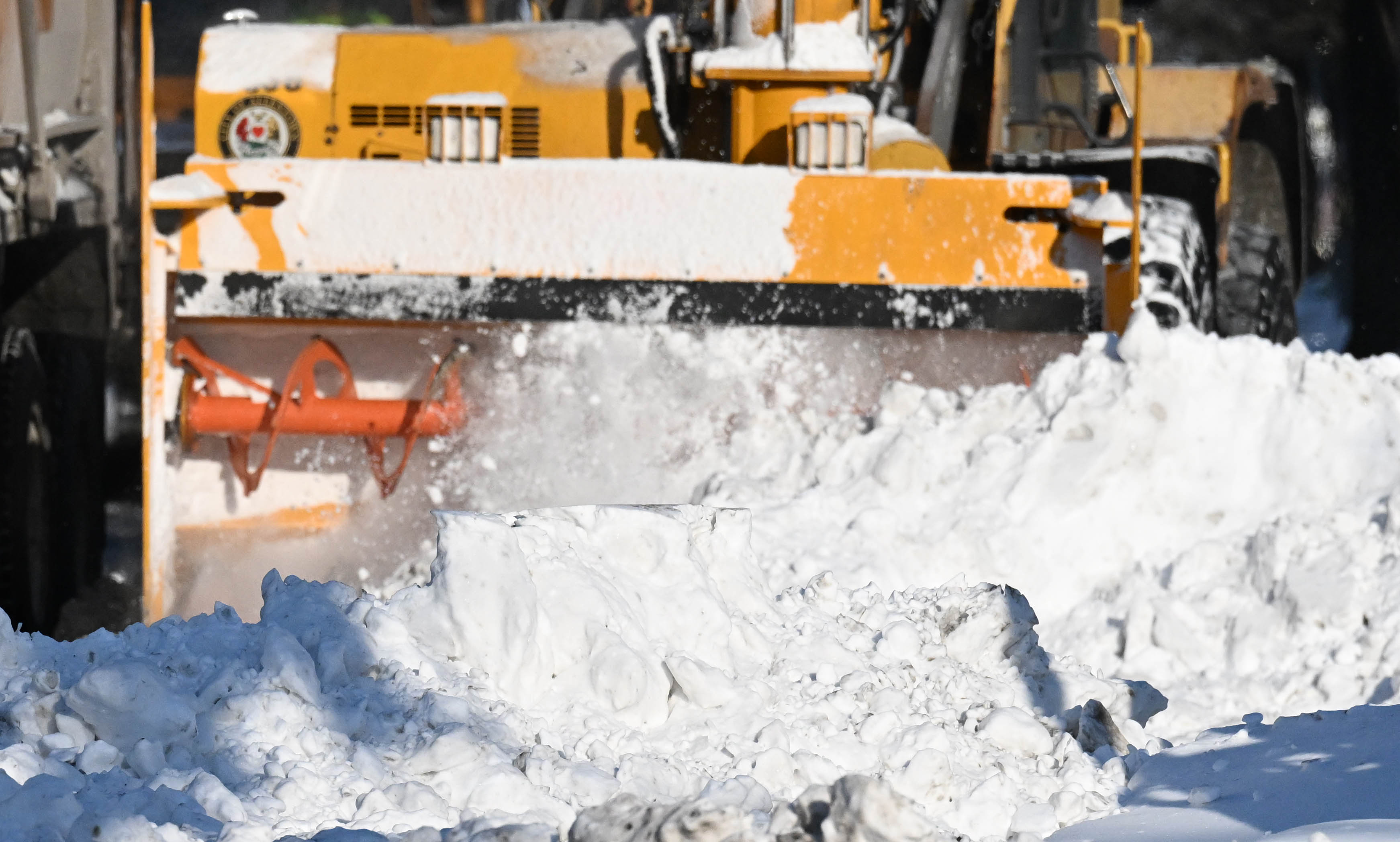 Workers from the Allentown Public Works Department clear snow from...