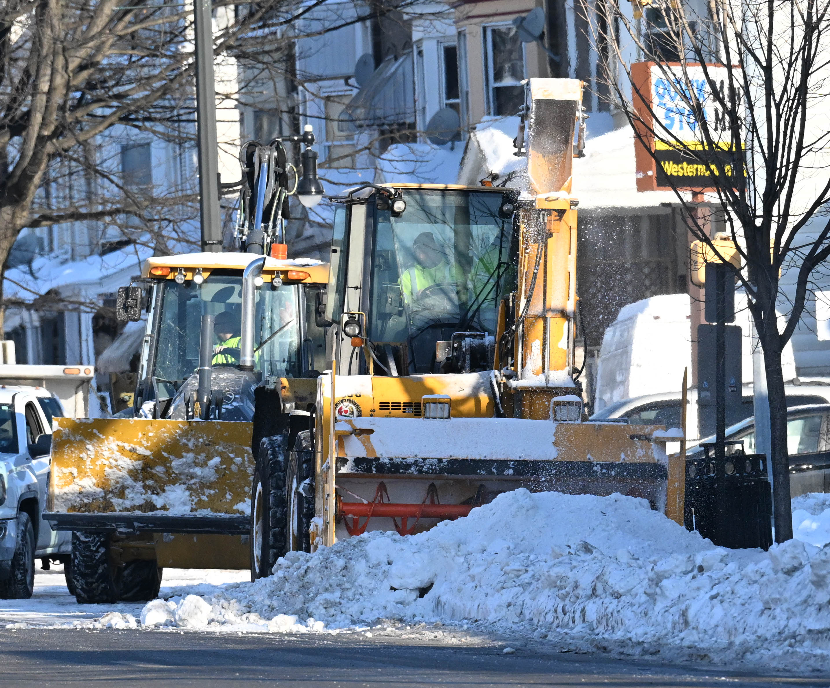 Workers from the Allentown Public Works Department clear snow from...