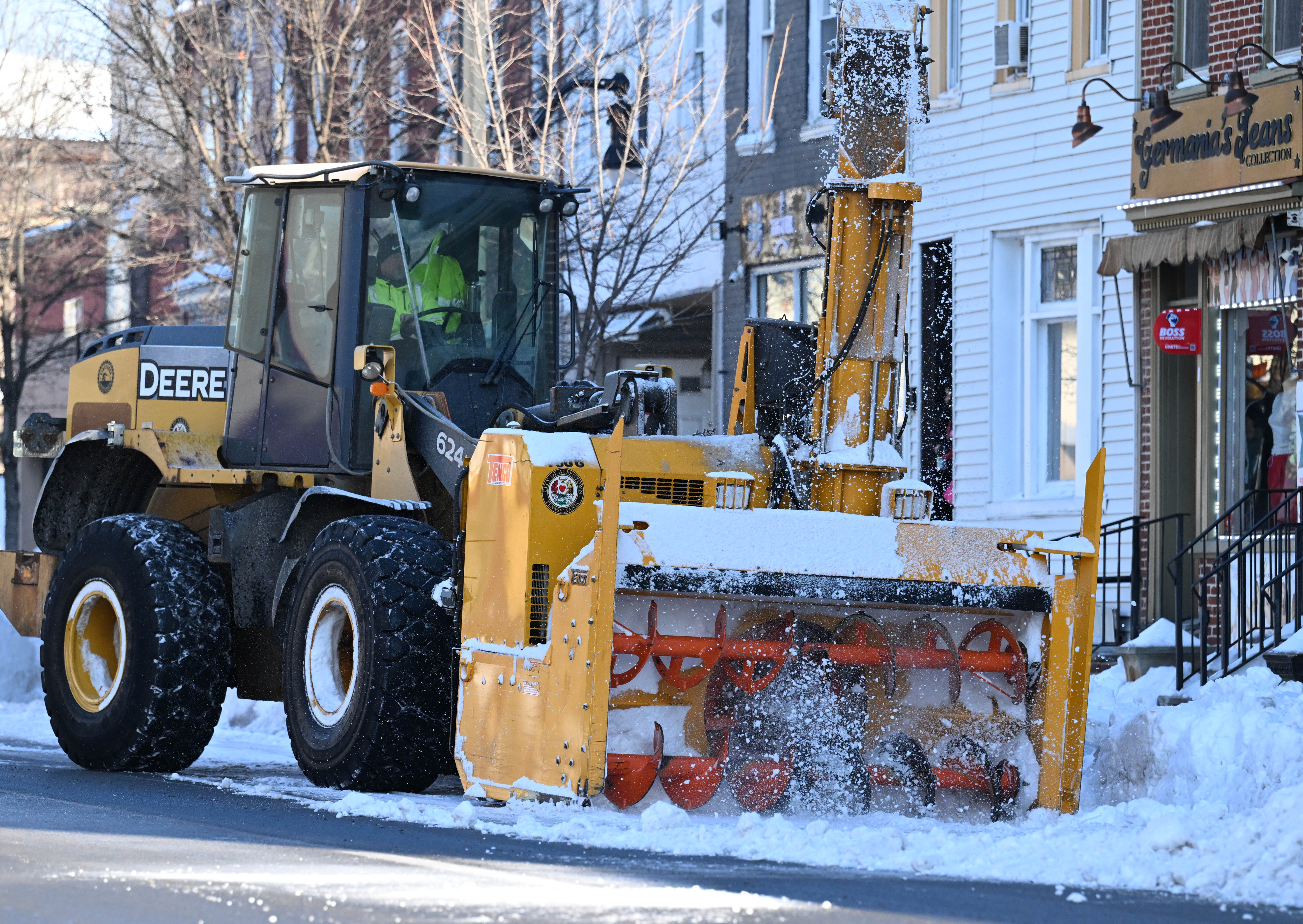 Workers from the Allentown Public Works Department clear snow from...