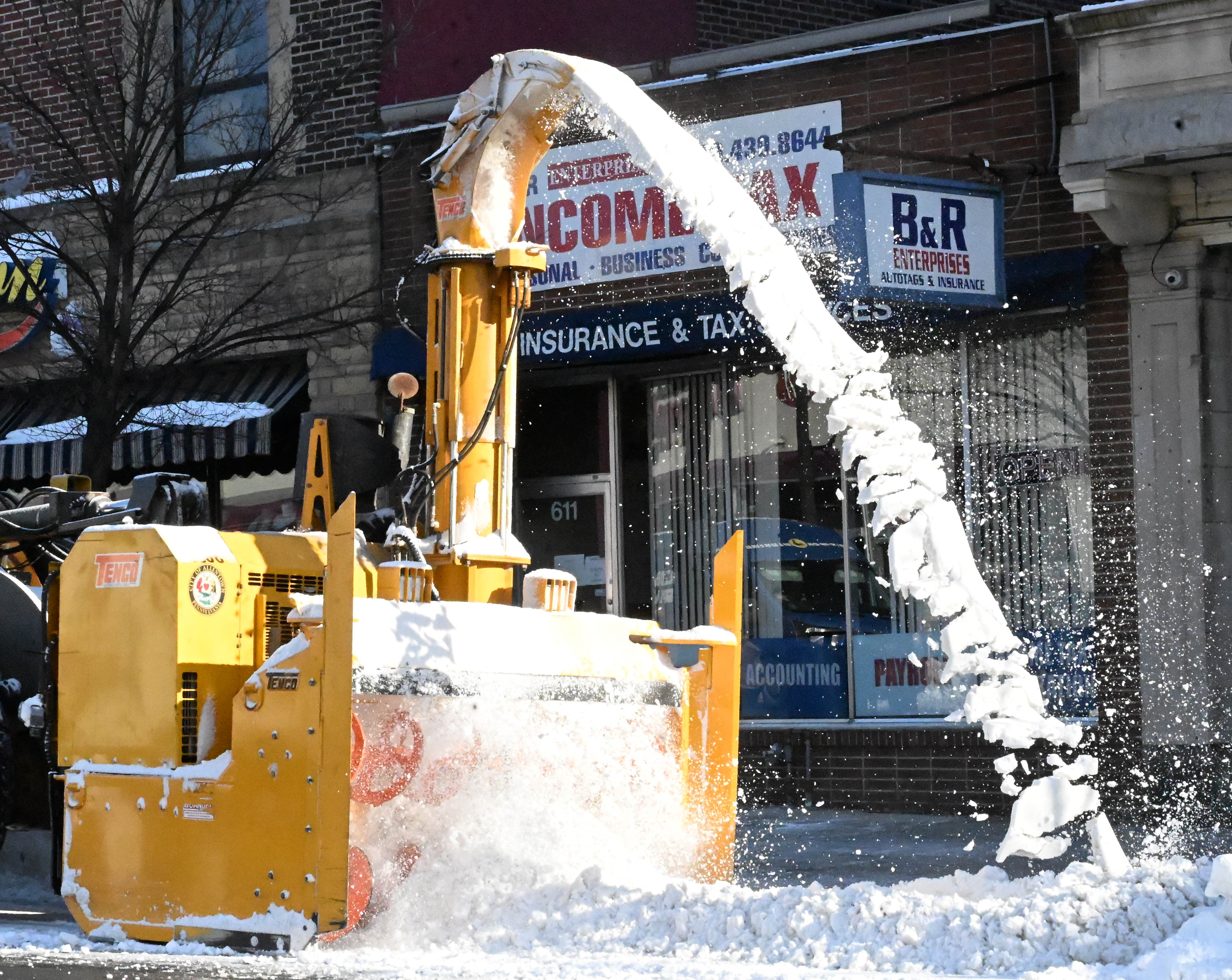 Workers from the Allentown Public Works Department clear snow from...