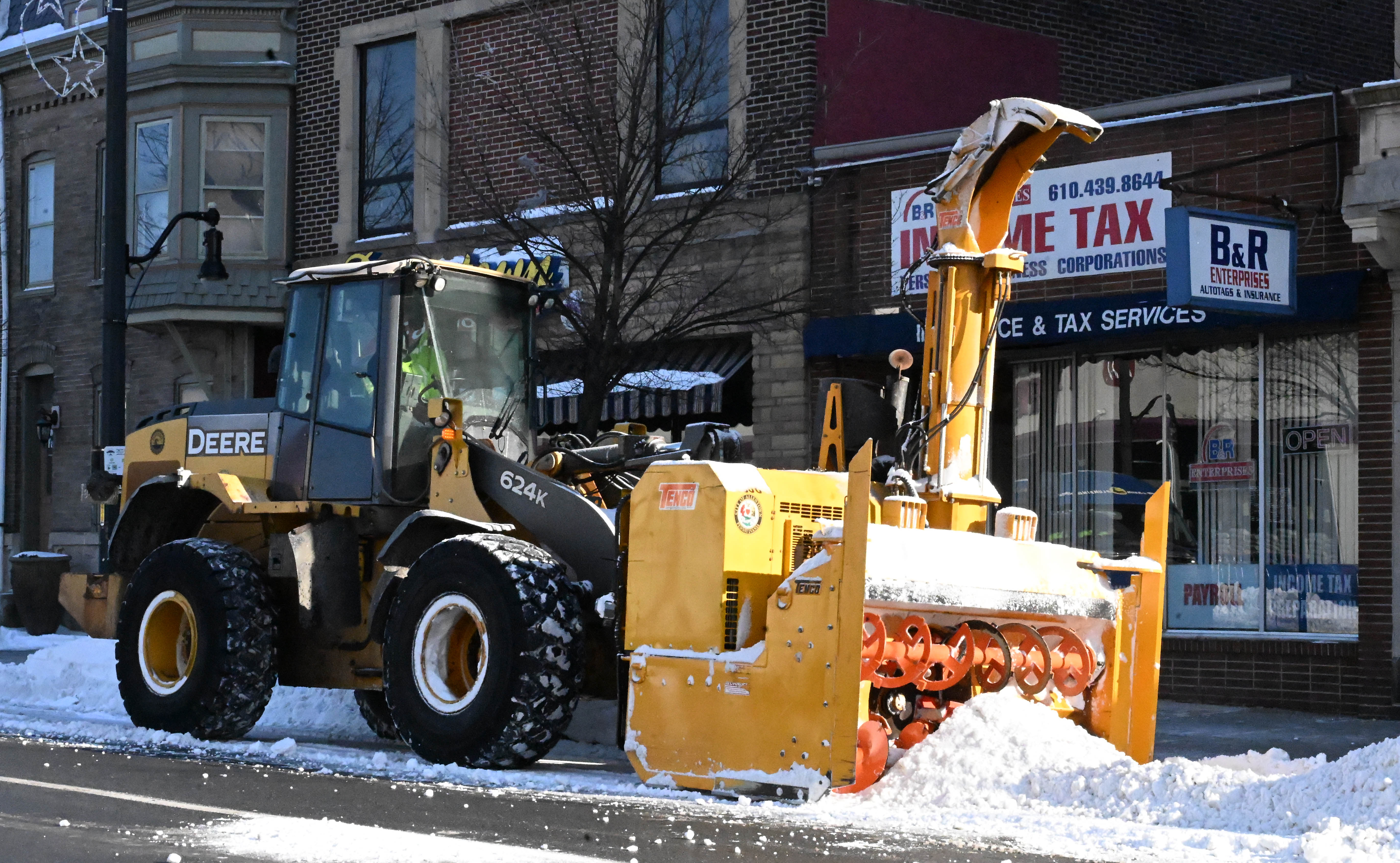 Workers from the Allentown Public Works Department clear snow from...