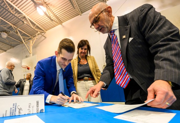 New Lehigh County Executive Josh Siegel signs his oath of office paperwork as executive assistant Jill Orosky and Lehigh County President Judge Douglas G. Reichley watch Monday, Jan. 5, 2026, following Siegel's swearing-in ceremony at The Boys and Girls Club of Allentown Cumberland Gardens Clubhouse. (April Gamiz / The Morning Call)