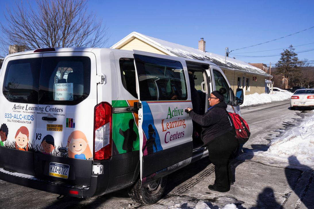A staff member welcomes children arriving for after school care at Active Learning Centers Emmaus.