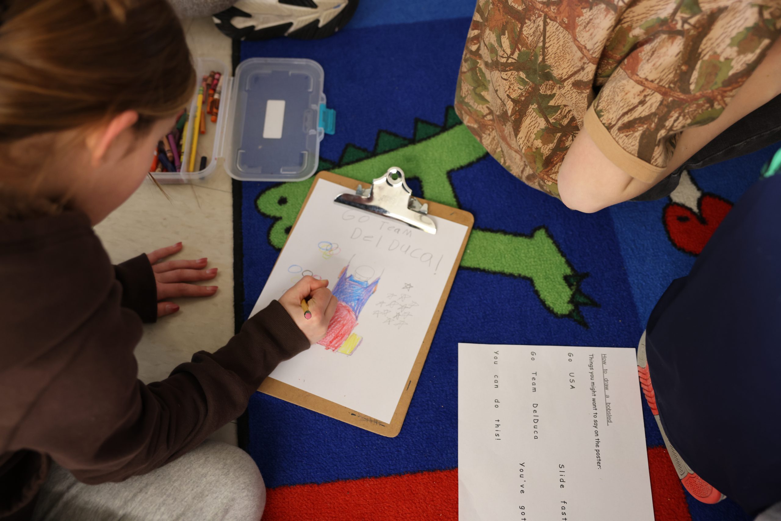 student drawing with pencil and crayons