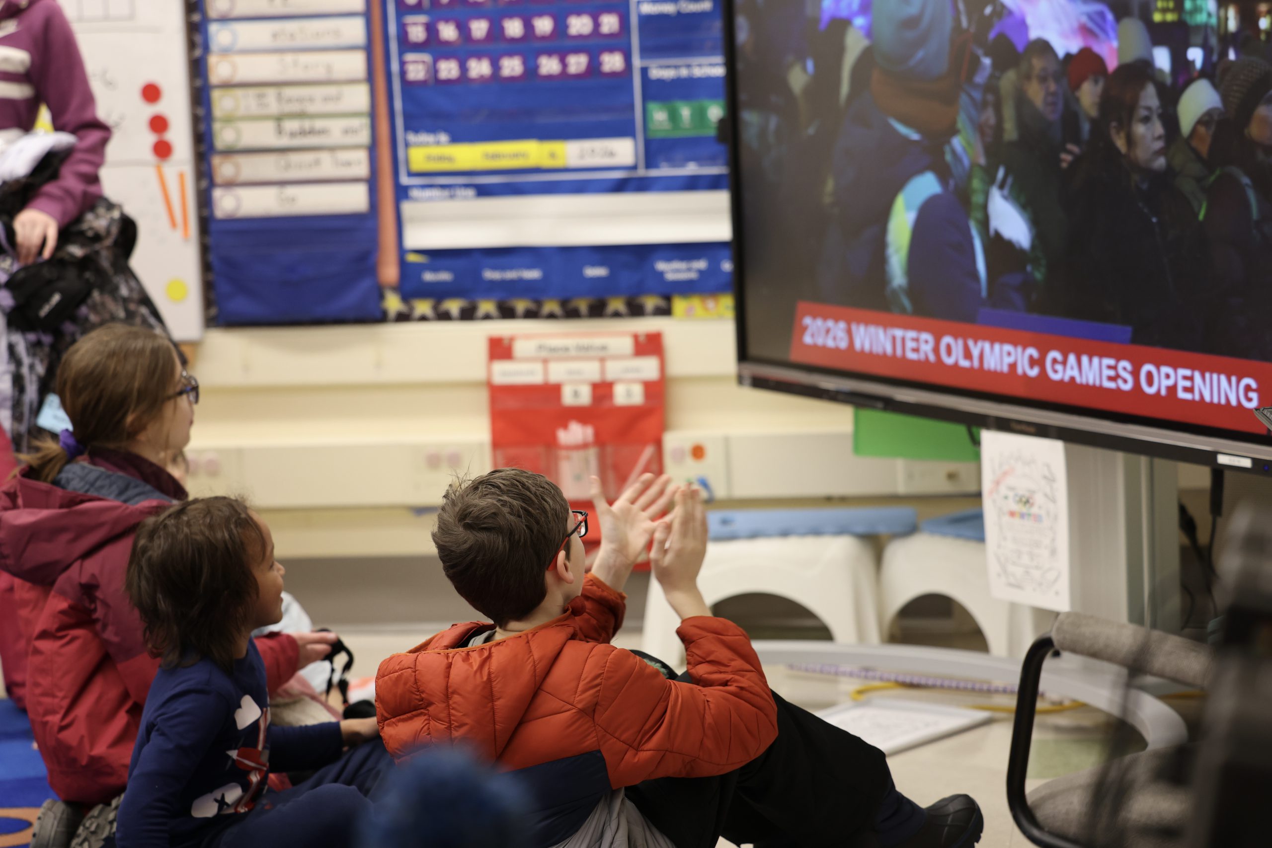 students clapping in front of screen