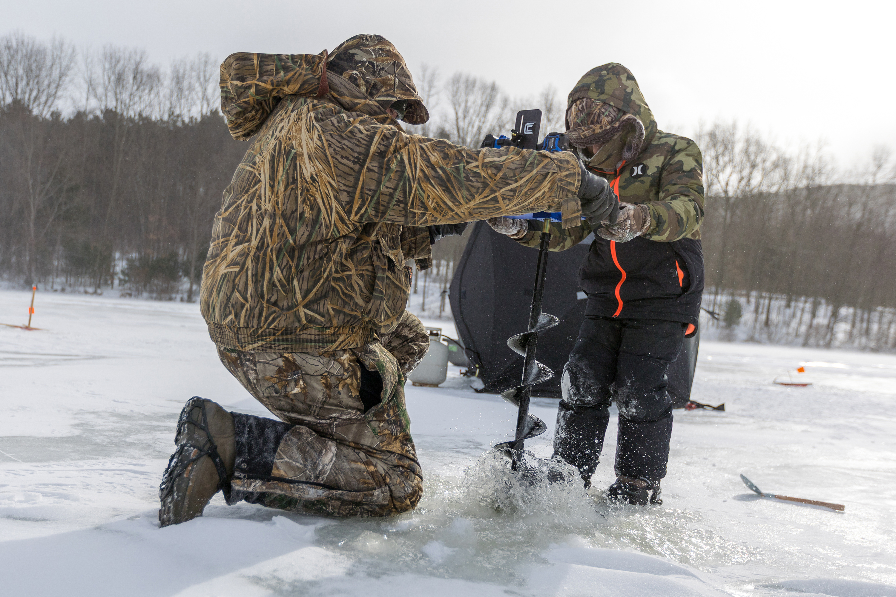 Cole Murdoch, 9, of Luzerne, and his father, Brian, drill...