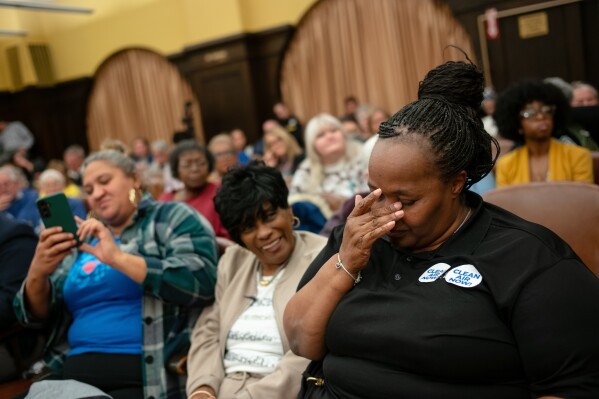 Carla Beard-Owens, right, and Jackie Wade, center, both of Clairton, celebrate on Tuesday, Nov. 18, 2025, as the Allegheny County Council voted to increase the fees levied on U.S. Steel and other industrial facilities in an effort to buttress the chronically underfunded Allegheny County Health Department, which regulates the Clairton Coke Works. (Quinn Glabicki/Pittsburgh's Public Source via AP)