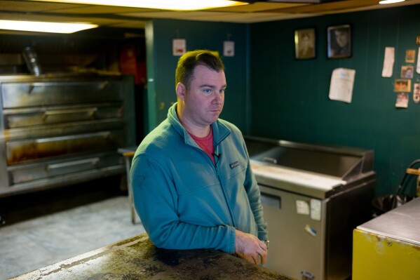 Former U.S. Steel worker Jonathan Ledwich stands at the pizza shop he now owns in Trafford, Pa., on Monday, Dec. 15, 2025. (Quinn Glabicki/Pittsburgh's Public Source via AP)