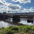 A bridge over the Conestoga River with blue sky and white clouds