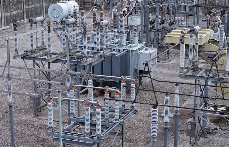 High voltage power lines run through a sub-station along an electrical power grid.
