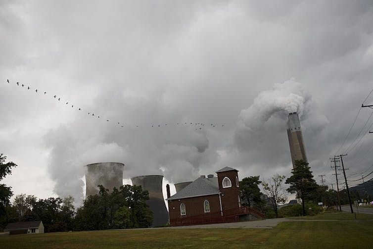 A power plant emits smoke and steam.