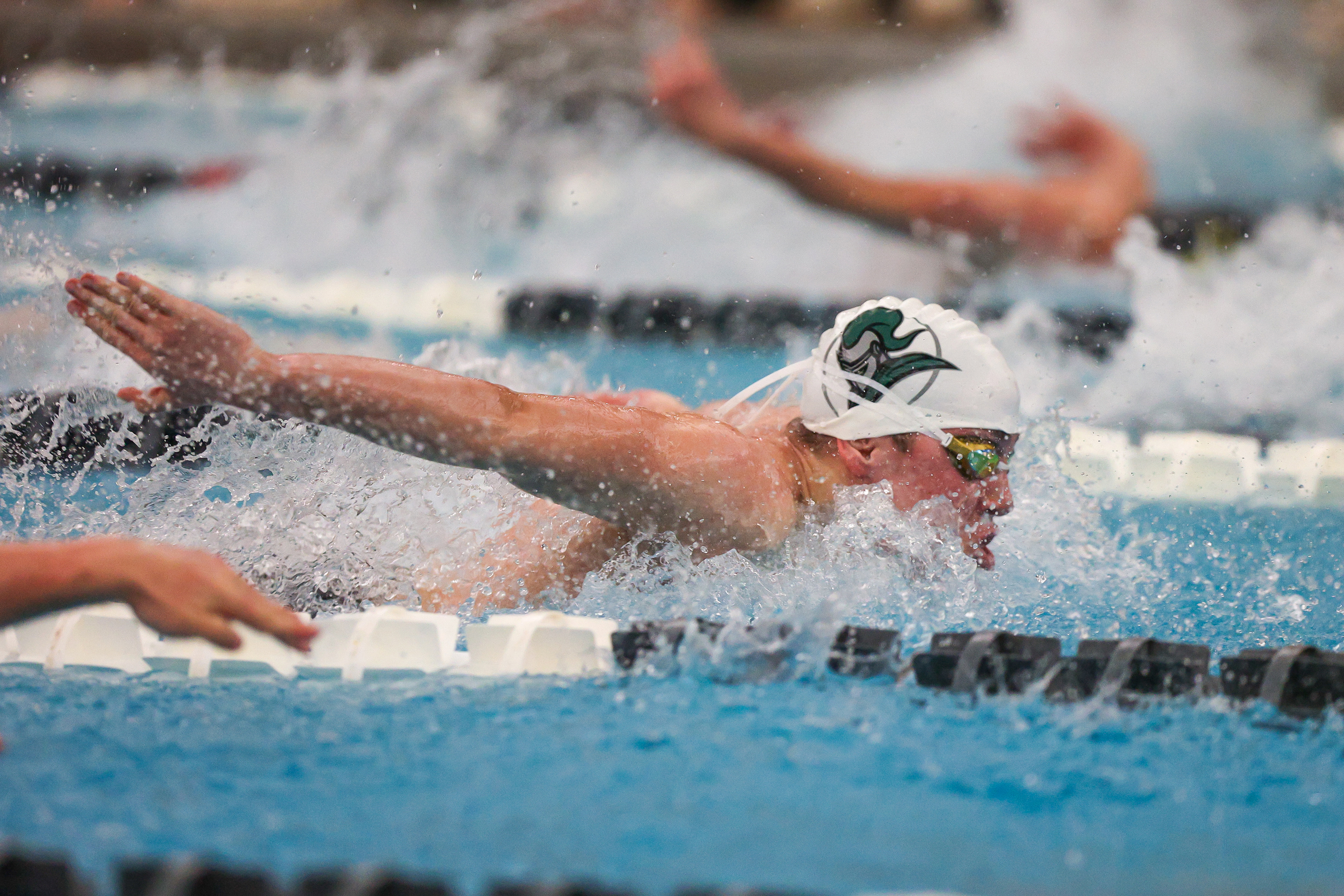 Holy Cross’ Leo Cholish swims the 100 butterfly during the...