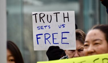 People hold up sign during a rally to restore the President