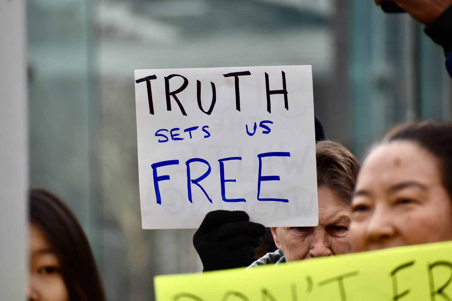 People hold up sign during a rally to restore the President