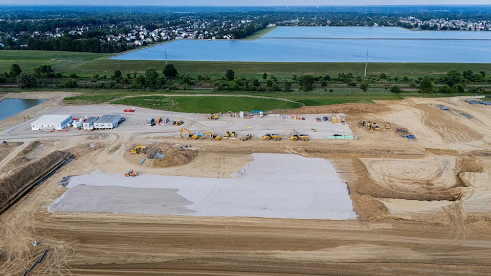 Construction vehicles and equipment surround  AI data center.
