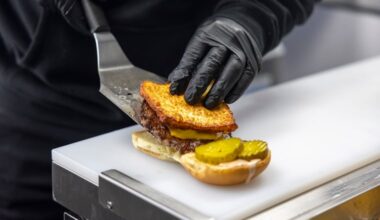 El Sazón R.D. co-owner Ari Valerio assembles the restaurant's viral Dominican smashburger at the restaurant's first Philly location, located at 1030 N 2nd St.