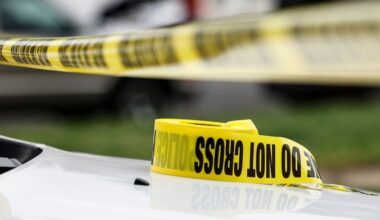 A file photo of police caution tape on the hood of a police vehicle in May 2024.