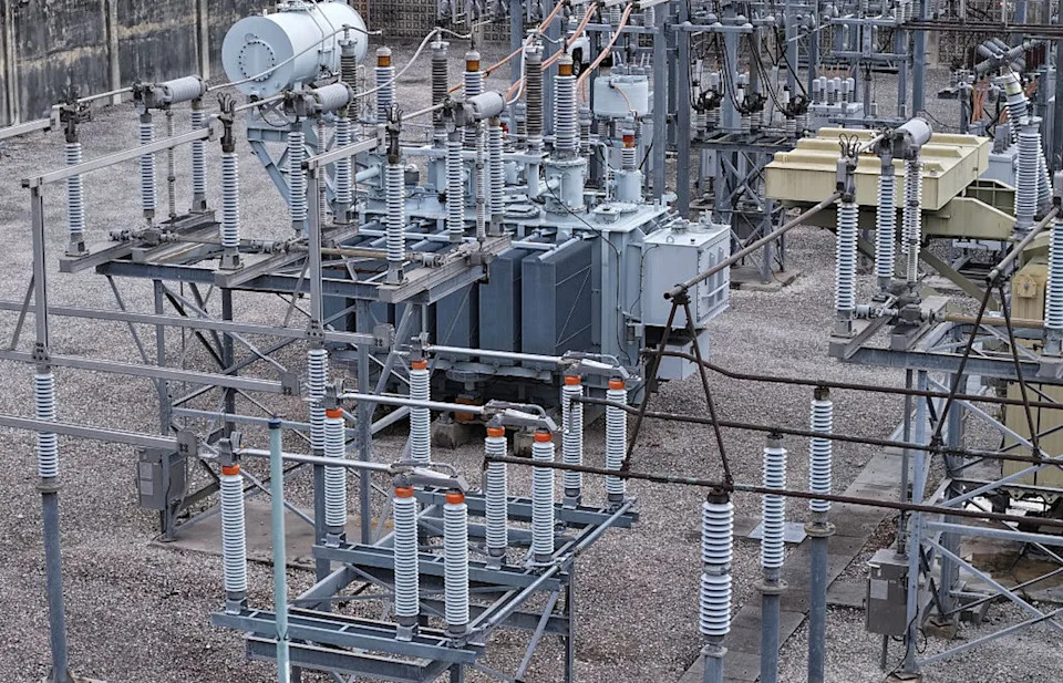 High voltage power lines run through a sub-station along an electrical power grid.