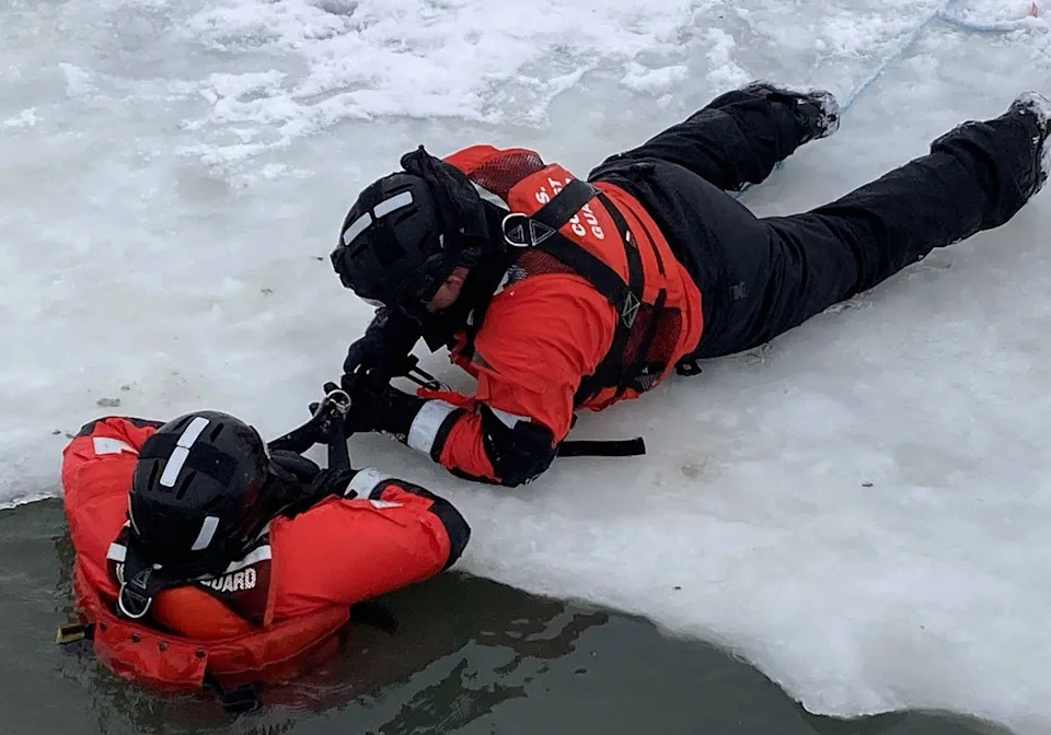 Coast Guard Petty Officer 2nd Class Gage Downer, right, latches onto Coast Guard Machinery Technician 2nd Class Britney Benoit during an ice rescue drill Feb. 3 in the waters off Coast Guard Station Erie at Presque Isle State Park.