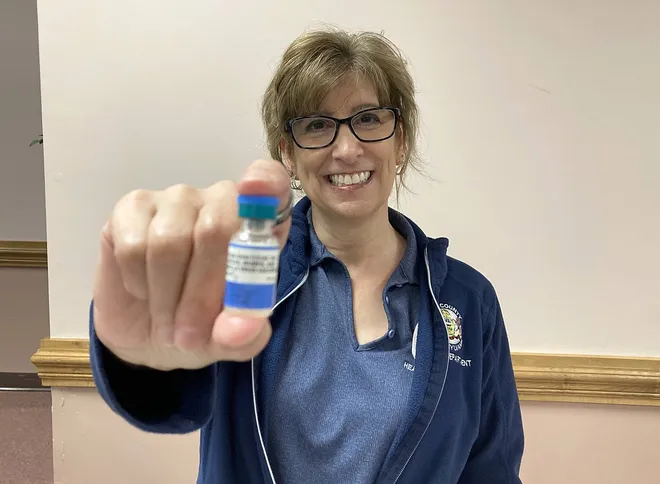 Michelle Bessetti, R.N., a nursing supervisor with the Erie County Department of Health, holds a container of measles, mumps and rubella vaccine during a vaccination clinic held April 22 at the Zem Zem Shrine Club, 2525 W. 38th St.