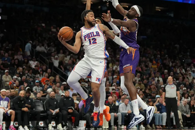 Feb 7, 2026; Phoenix, Arizona, USA; Philadelphia 76ers forward Trendon Watford (12) drives around Phoenix Suns center Mark Williams (15) during the second half of an NBA game at Mortgage Matchup Center. Mandatory Credit: Rick Scuteri-Imagn Images