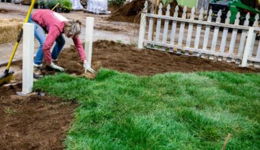 Natalie Ross with Kelly D.  Norris, of Des Moines, Iowa places sod behind a white picket fence at the Convention Center Tuesday, Feb. 24, 2026, setting up for the PHS Philadelphia Flower Show. The display is part of the  “American Landscape Showcase” and is titled, “American Anemoia.”