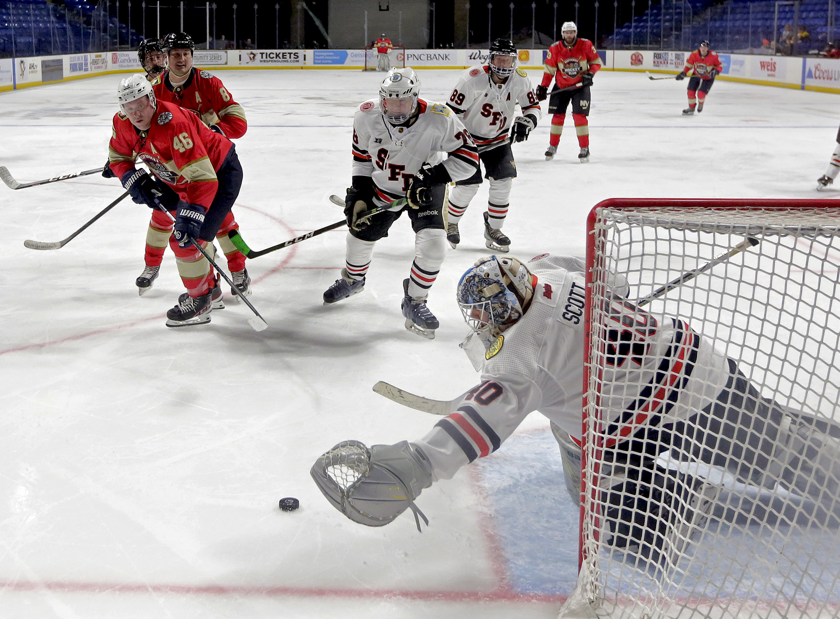 Scranton goalkeeper Jim Scott (40) dives for the puck after...