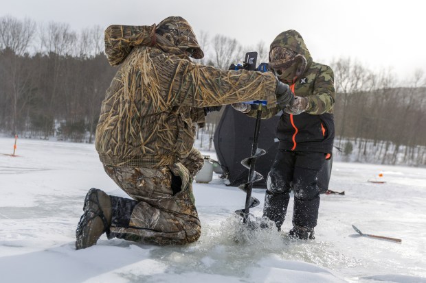 Cole Murdoch, 9, of Luzerne, and his father, Brian, drill a hole in the ice during the Nanticoke Conservation Club ice fishing derby at Frances Slocum State Park on Saturday, Feb. 7, 2026. (JASON ARDAN / STAFF PHOTOGRAPHER)