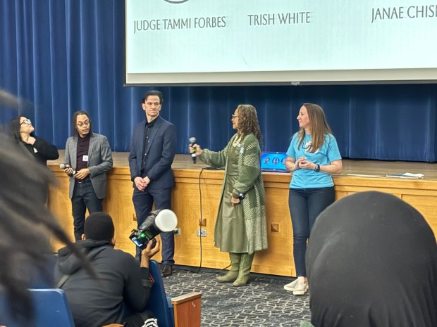 District Judge Tammi Forbes of Darby hands the microphone over to Chris Dyer at Academy Park High School on Saturday with teacher Susan Reutter on the right. (KATHLEEN E. CAREY - DAILY TIMES)