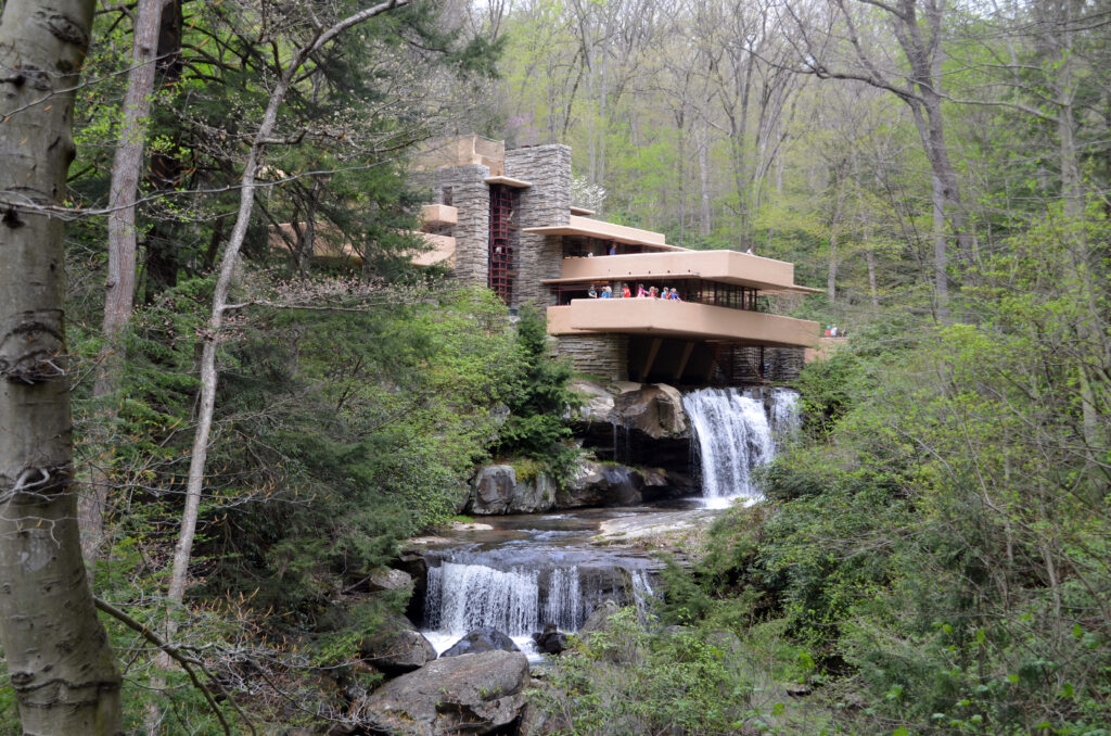 The view shows the house's terraces and the waterfall as well as the forest around it