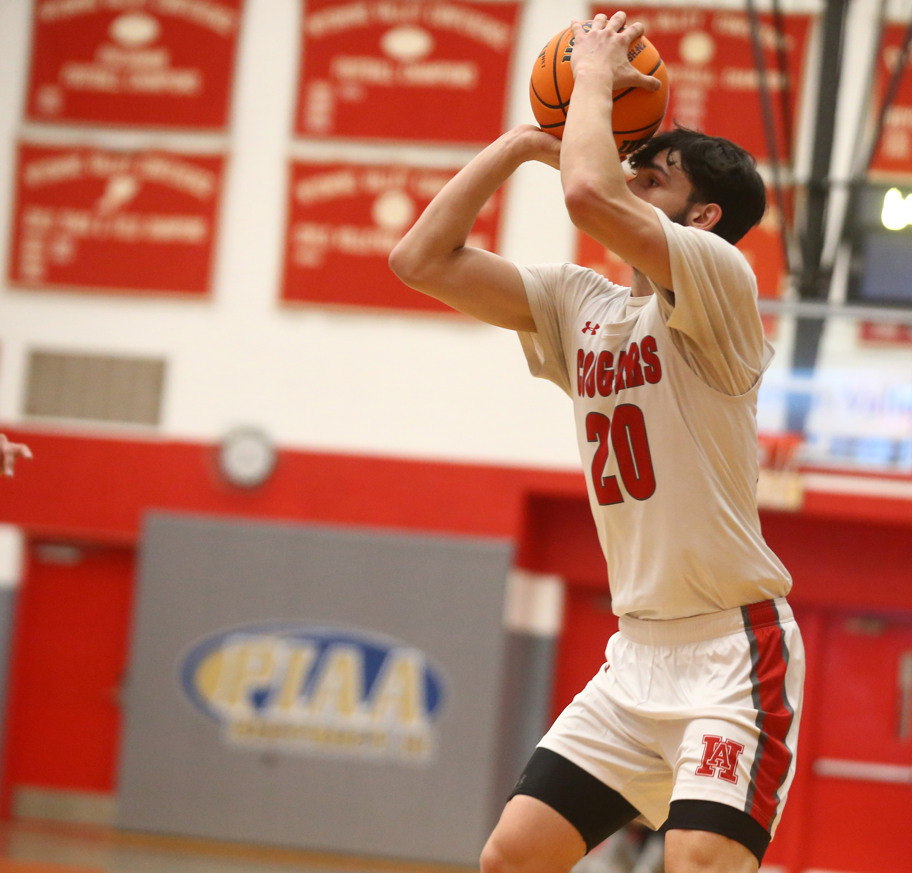 Hazleton Area’s Dylan Stish (20) eyes the basket for one...