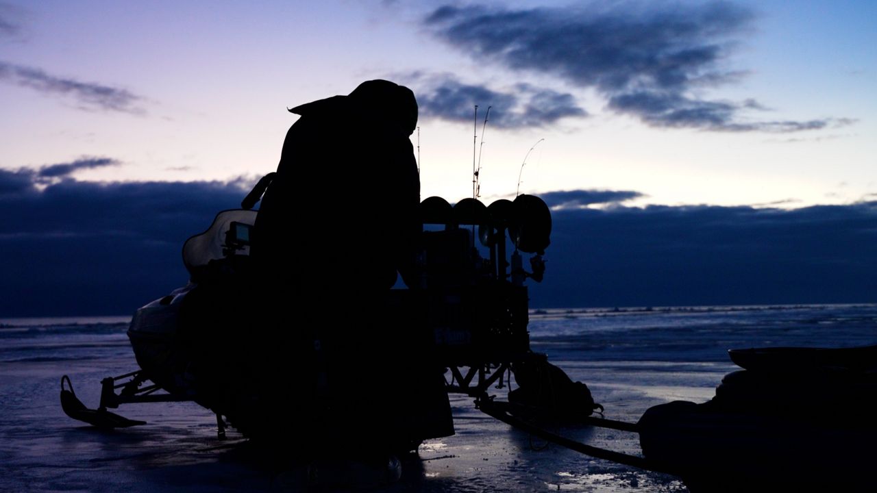 Ice fisher John Fickert set's up his gear as the sun rises on Lake Erie.