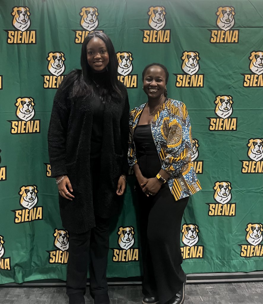two people standing in front of banner
