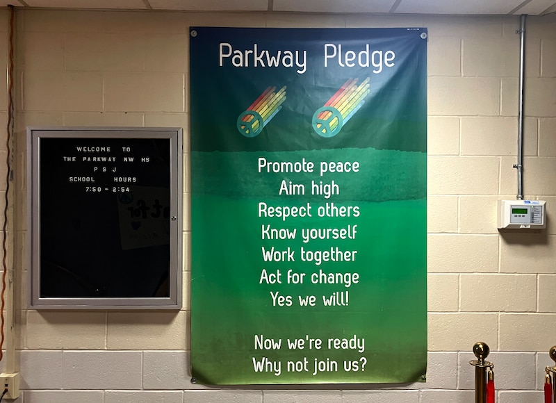 A green banner hangs on a wall.