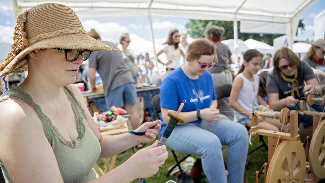Hannah Black uses a drop spindle to spin yarn along side the Centre Spinners at the People’s Choice Festival of Pennsylvania Arts & Crafts at the Pennsylvania Military Museum in Boalsburg on Friday, July 12, 2019.