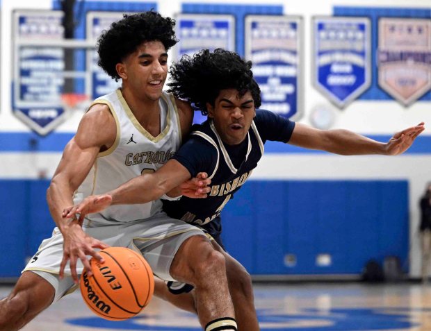 Bishop McDevitt's Tommy Jones fouls Berks Catholic's Kingston McKoy during the Saints' 58-52 overtime District 3 Class 4A victory over the Crusaders on Friday, Feb. 27, 2026, at Garden Spot High School in New Holland. (BILL UHRICH/READING EAGLE)