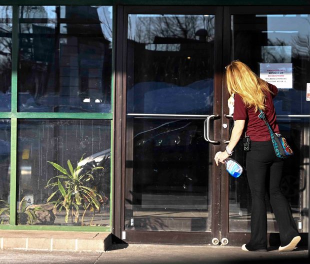 A woman cleans the window on the entrance to the Berkshire Mall. The sale of the mall to Abrams Reality is expected to close in May. (BILL UHRICH/READING EAGLE)