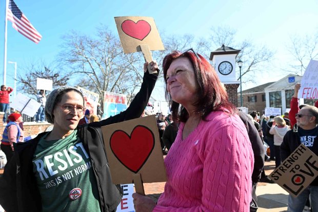 Amber Kulaga, left, and Susan Blakely, both of Shillington, protest in Wyomissing Saturday against the Immigration and Customs Enforcement purchase of a warehouse in Upper Bern Township for use as a processing facility for detainees. (BILL UHRICH/READING EAGLE)