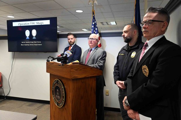 Berks County District Attorney John T. Adams, at podium, on Monday announces the arrests of smoke shop operators accused of selling hemp products with higher than lawful THC levels, the active ingredient in marijuana. From left are Assistant District Attorney Daniel Troy, Adams, West Reading Police Chief Richard Tornelli and Chief Berks County Detective Michael J. Gombar. (BILL UHRICH/READING EAGLE)
